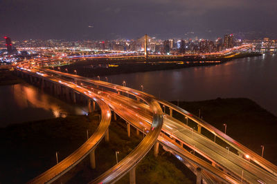 High angle view of light trails on bridge over river at night