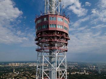 Low angle view of water tower amidst buildings against sky