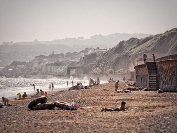 People at beach against sky