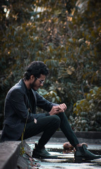 Young man using mobile phone while sitting outdoors