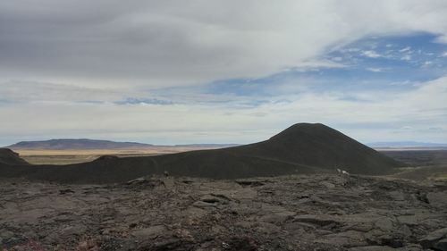 Scenic view of mountain range against cloudy sky