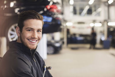 Portrait of happy mechanic in auto repair shop