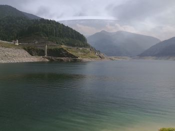 Scenic view of river and mountains against sky