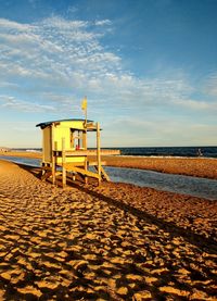 Lifeguard hut on beach against sky