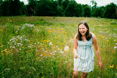 Young woman with yellow flowers on field