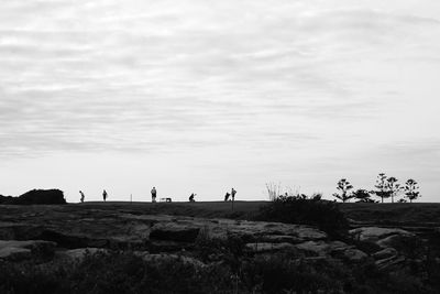 Mid distance of people on landscape against sky