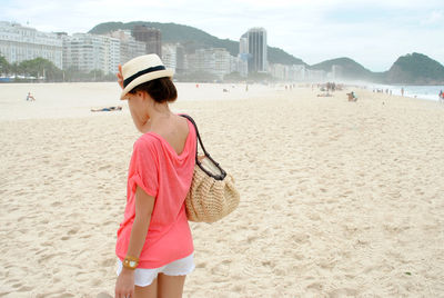 Rear view of woman standing on beach