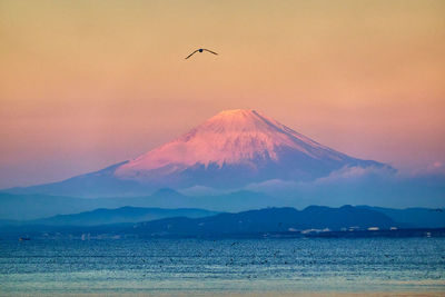 Scenic view of snowcapped mountains with against sky during sunrise