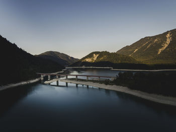 Scenic view of lake and mountains against clear sky