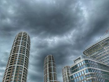 Low angle view of buildings against cloudy sky