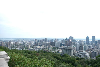 Aerial view of buildings in city against clear sky