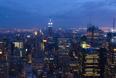 Illuminated cityscape against sky at night