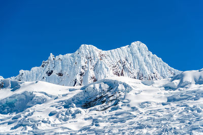 Snowcapped mountains against clear blue sky