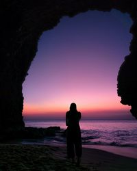 Silhouette people on beach against sky during sunset