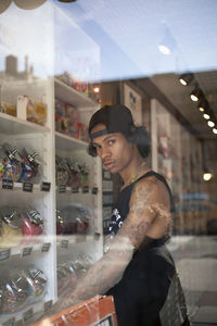 Side view of young man standing in store