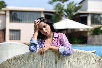 Portrait of young woman sitting on pool side