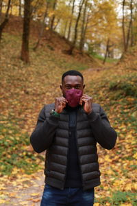 Portrait of man wearing sunglasses standing in forest