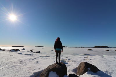 Rear view of woman walking on snow