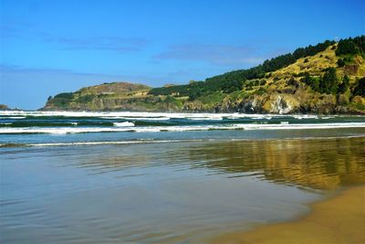 Scenic view of sea and mountains against sky