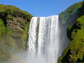 Scenic view of waterfall against sky