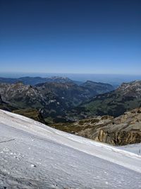 Scenic view of snowcapped mountains against clear blue sky