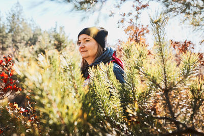 Woman enjoying hike on sunny vacation day. female with backpack walking through forest