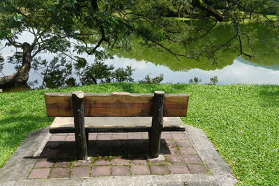 Rear view of woman sitting on bench against sky