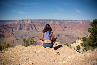 Rear view of woman standing on landscape against sky