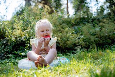 Cute caucasian girl eating watermelon in countryside