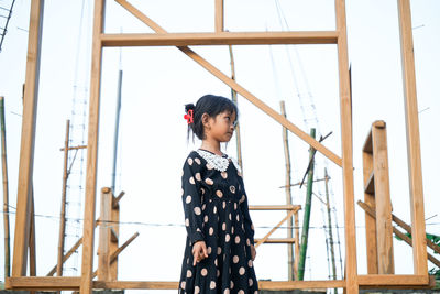 A little asian girl is angry in front of a house building