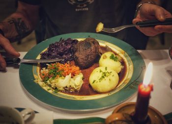 Midsection of man eating food at home