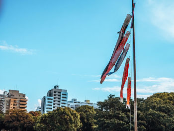 Low angle view of flags against blue sky