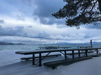 View of jetty in sea against cloudy sky