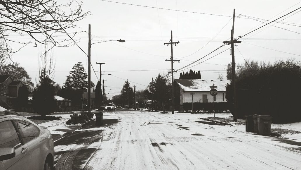 transportation, car, mode of transport, land vehicle, street, electricity pylon, road, power line, the way forward, tree, snow, street light, clear sky, sky, winter, cold temperature, electricity, diminishing perspective, bare tree, season