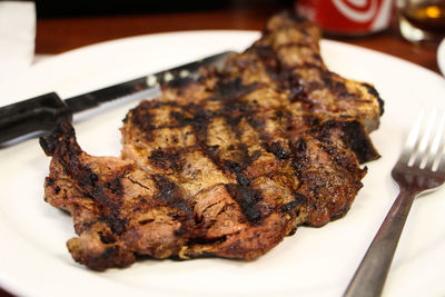 Close-up of smoked meat steaks in plate on table