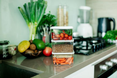 Fresh various vegetables and buckwheat in a container are on the table in the kitchen