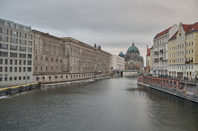 Bridge over river against buildings in city