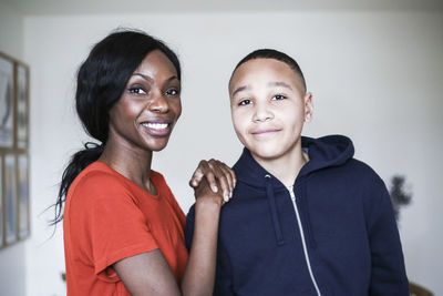 Portrait of smiling mother and son at home