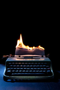 Close-up of illuminated candle against black background