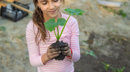 Midsection of woman holding plant