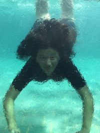 Portrait of woman swimming underwater in pool