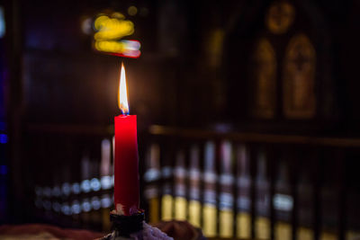 Close-up of lit candle in church