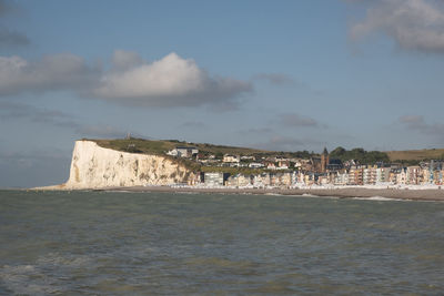 Scenic view of sea by buildings against sky