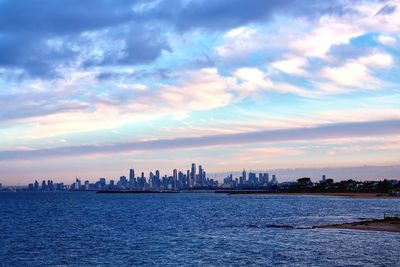 View of sea and buildings against sky during sunset