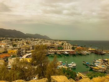 High angle view of townscape by sea against sky