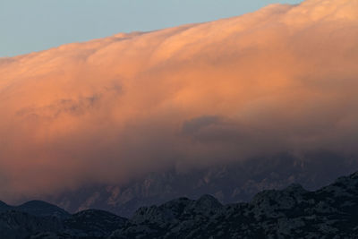 Scenic view of clouds above velebit  mountains against sky during sunset