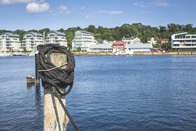 Scenic view of river by buildings against sky