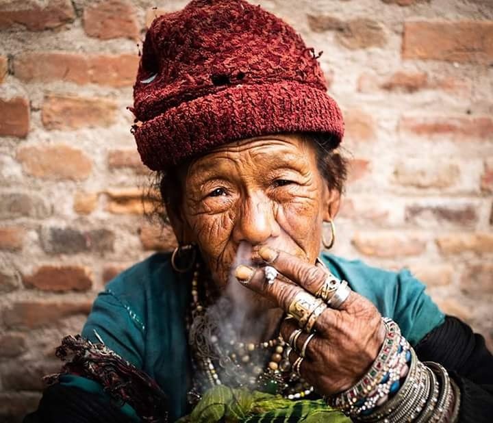 brick, one person, senior adult, clothing, brick wall, adult, wall, headshot, smoking issues, portrait, hat, front view, looking at camera, wall - building feature, wrinkled, sitting