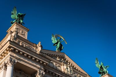 Low angle view of statue against blue sky