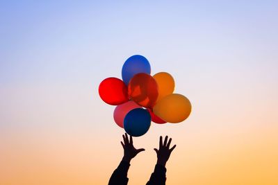 Low angle view of balloons against clear blue sky
